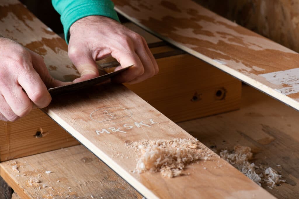 Grattage des skis en bois pour enlever les résidus de résines